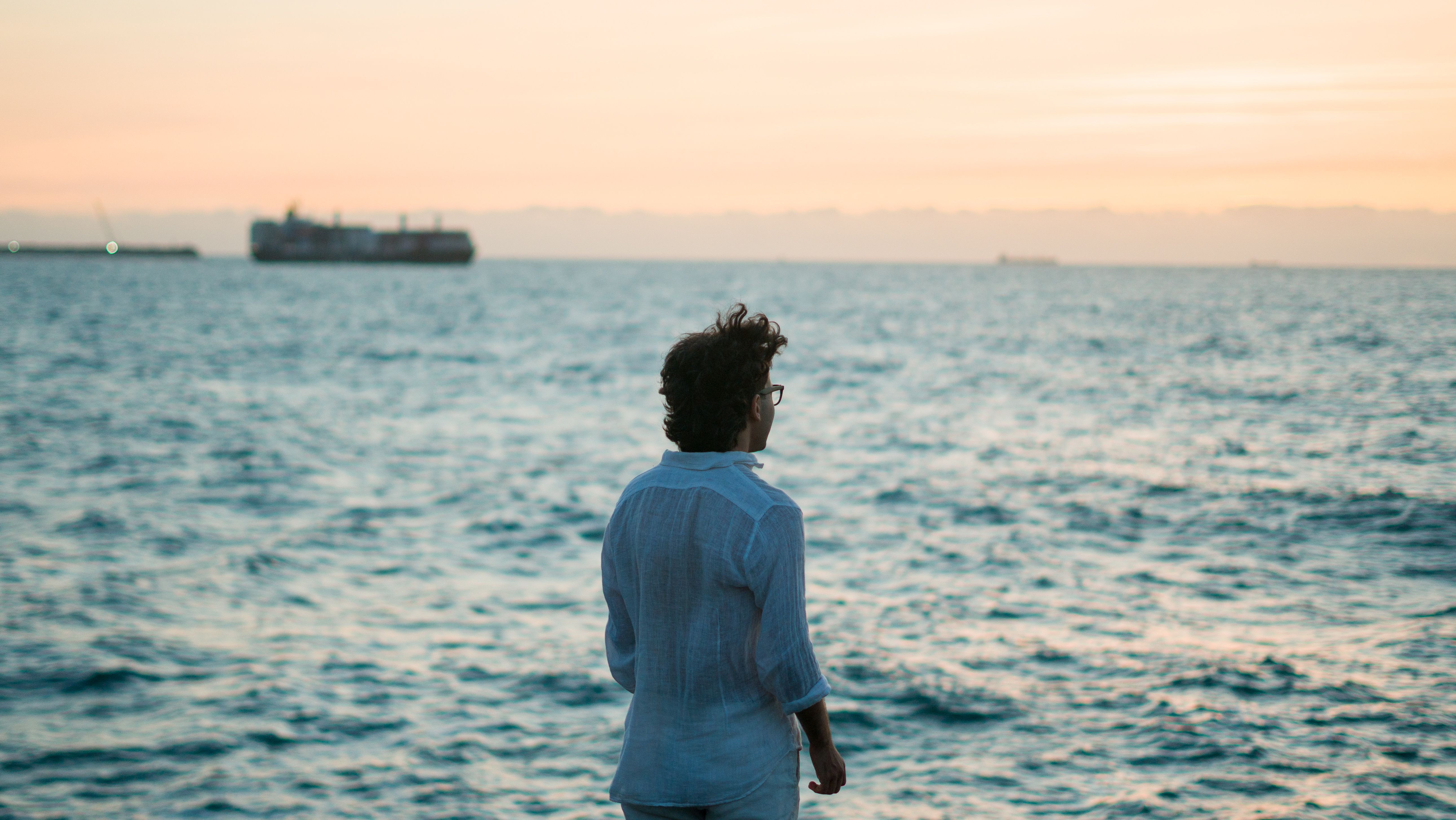 Contemplative Person Watching Sunset Over Ocean · Free Stock Photo