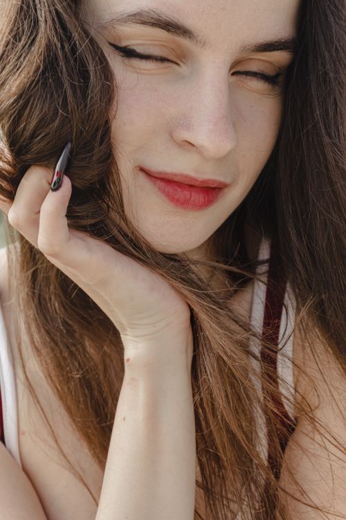Free Close-up portrait of a smiling woman with long hair and red lipstick. Stock Photo