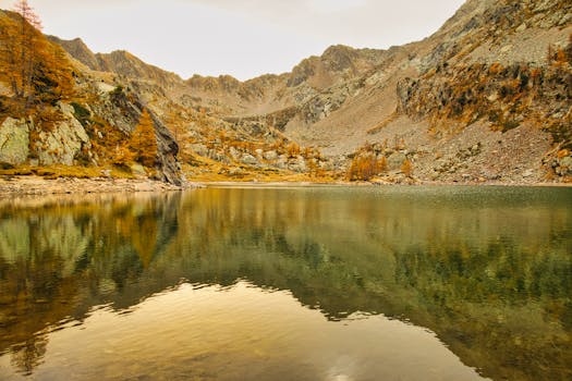 A tranquil autumn lake surrounded by mountains in Saint-Martin-Vésubie, France.