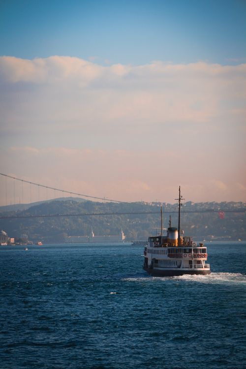 Free Ferry cruising on the Bosphorus Strait with a backdrop of Istanbul's skyline and bridge. Stock Photo
