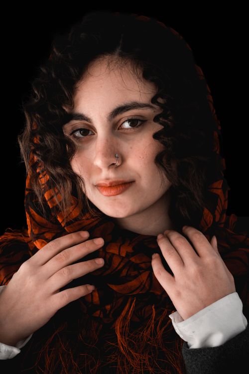 Free Close-up portrait of a woman wearing a patterned scarf, showcasing artistic flair and elegance. Stock Photo