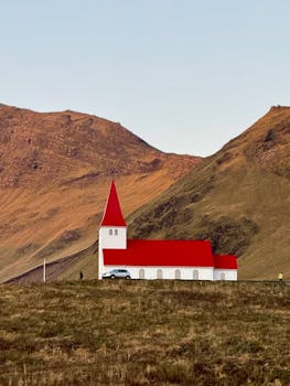 Charming red-roofed church nestled in the Icelandic highlands at sunset.