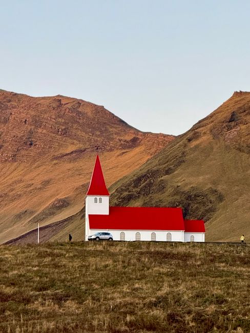 Charming red-roofed church nestled in the Icelandic highlands at sunset.