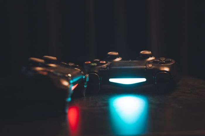 Backlit game controllers on a dark surface — photo by Furkan Salihoglu on Pexels