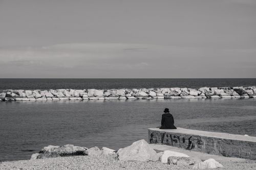 Free Black and white photo of a person in solitude by the sea. Stock Photo