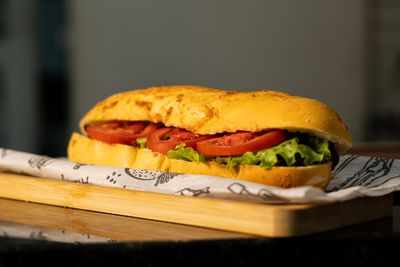 Sub roll with tomato and lettuce on a board — photo by ramon rangel on Pexels