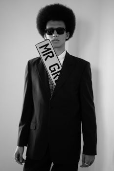 Black and white portrait of a man in a suit with an afro and sunglasses.
