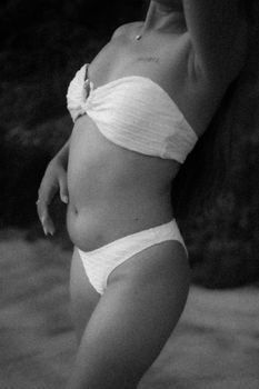 Artistic black and white portrait of a woman in a bikini, showcasing elegant beach style.