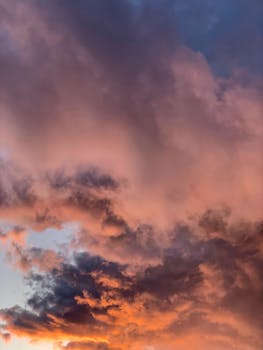 Stunning sunset with dramatic clouds creating a vibrant sky perfect for serene nature backgrounds.