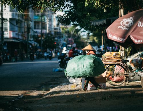 Free A street vendor with conical hat selling goods in Kon Tum, Vietnam. Stock Photo