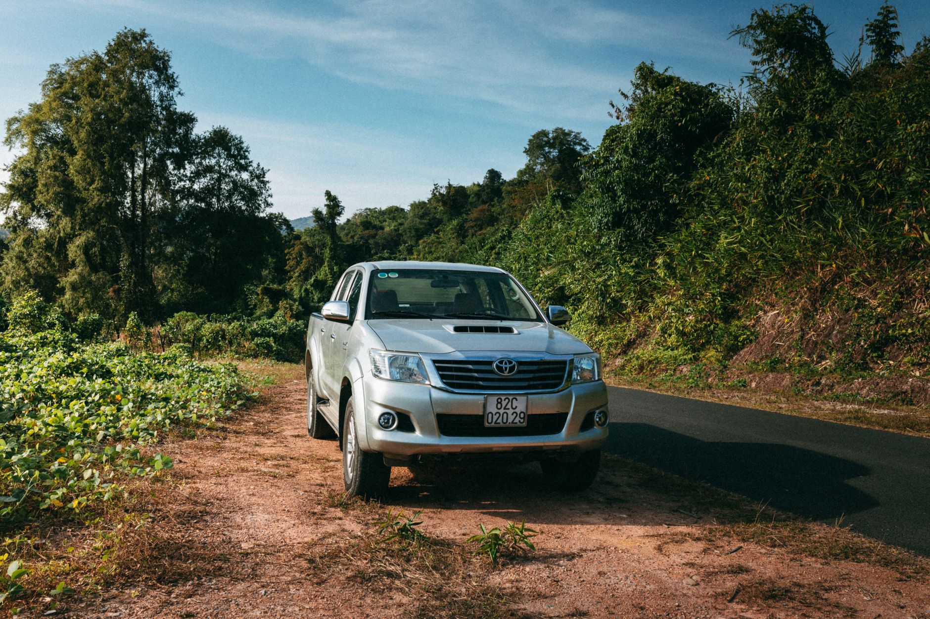 Pickup truck 4x4 en camino rural, similar a una Toyota Hilux usada en El Salvador