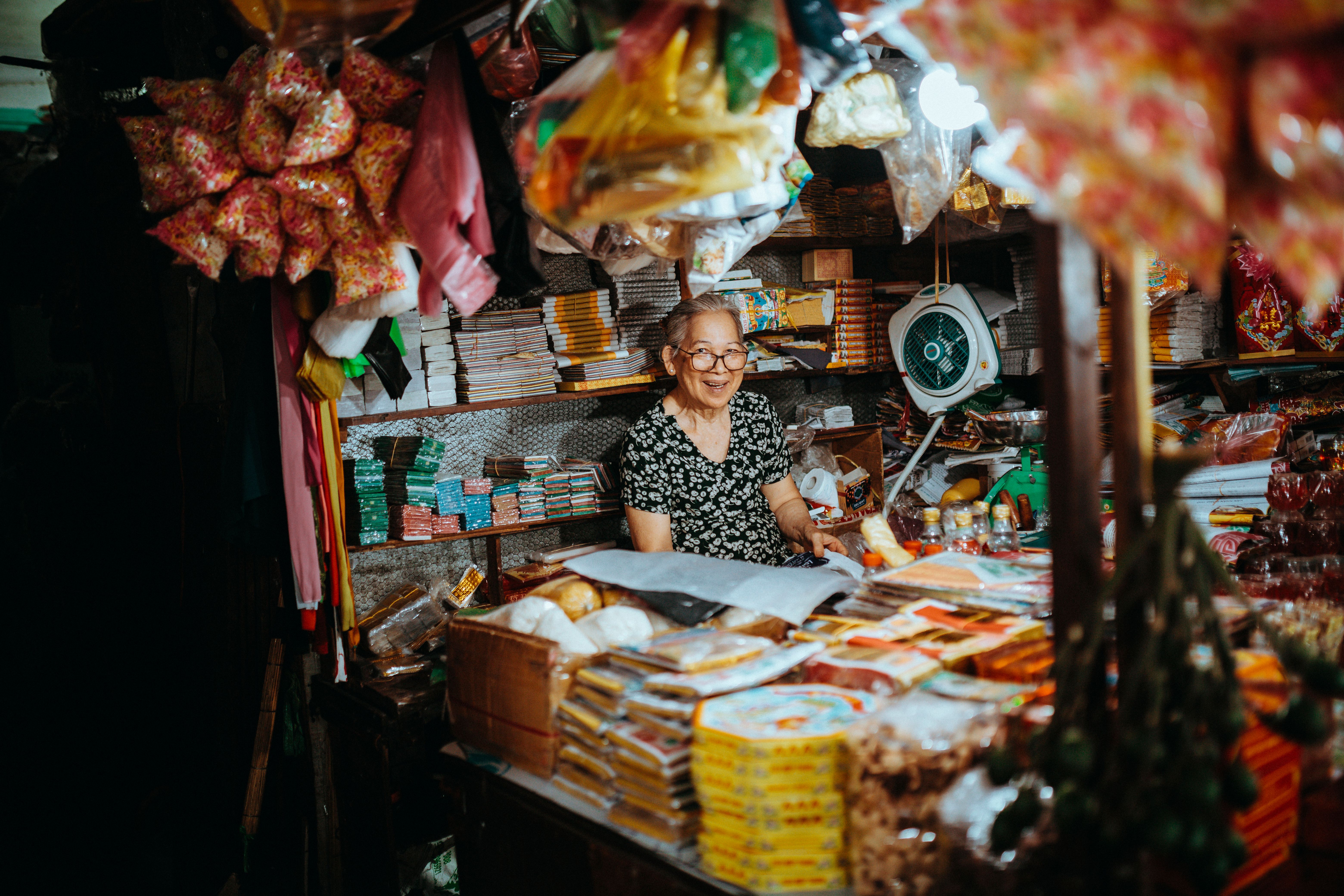 Smiling Shopkeeper in a Vietnamese Market Stall · Free Stock Photo