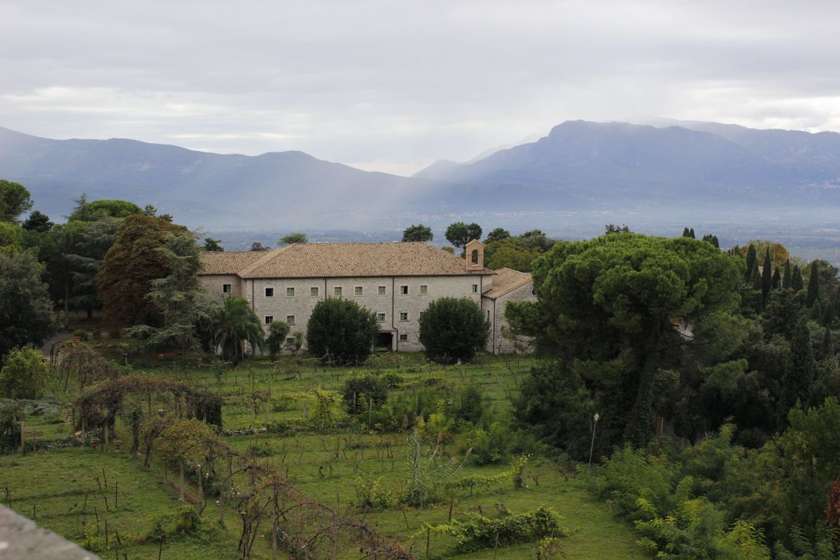 Complex monastic cu gradini, intr-o vale, cu munti in ceata