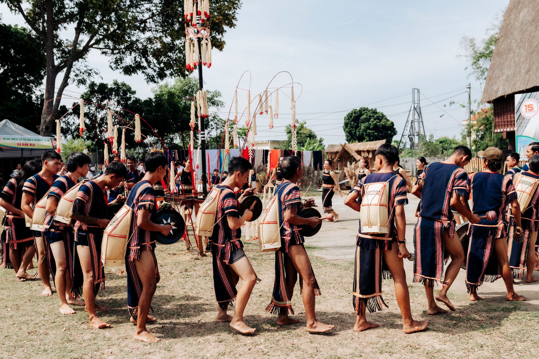 Vietnamese village festival with a traditional cockfighting ring, red banners, elders watching, and autumn sunlight