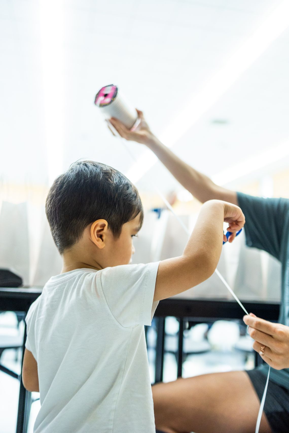 Young child working on a hands-on craft activity with supportive adult guidance