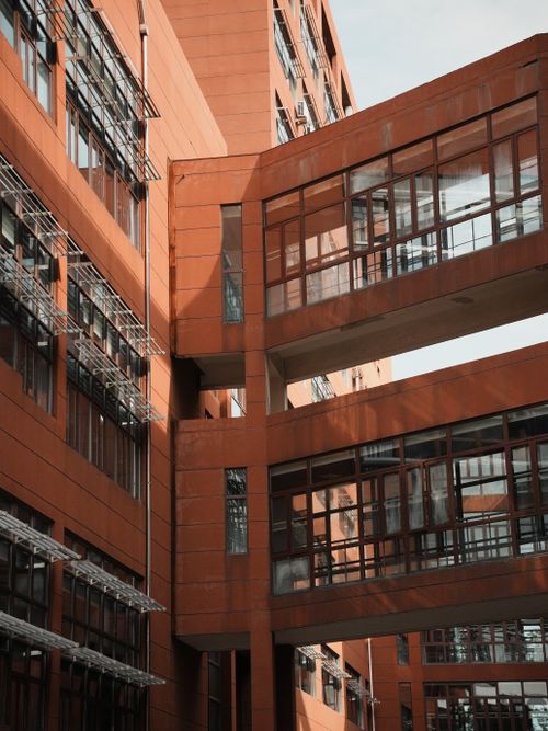 Free Contemporary building with red facade and interconnecting walkways in sunlight. Stock Photo