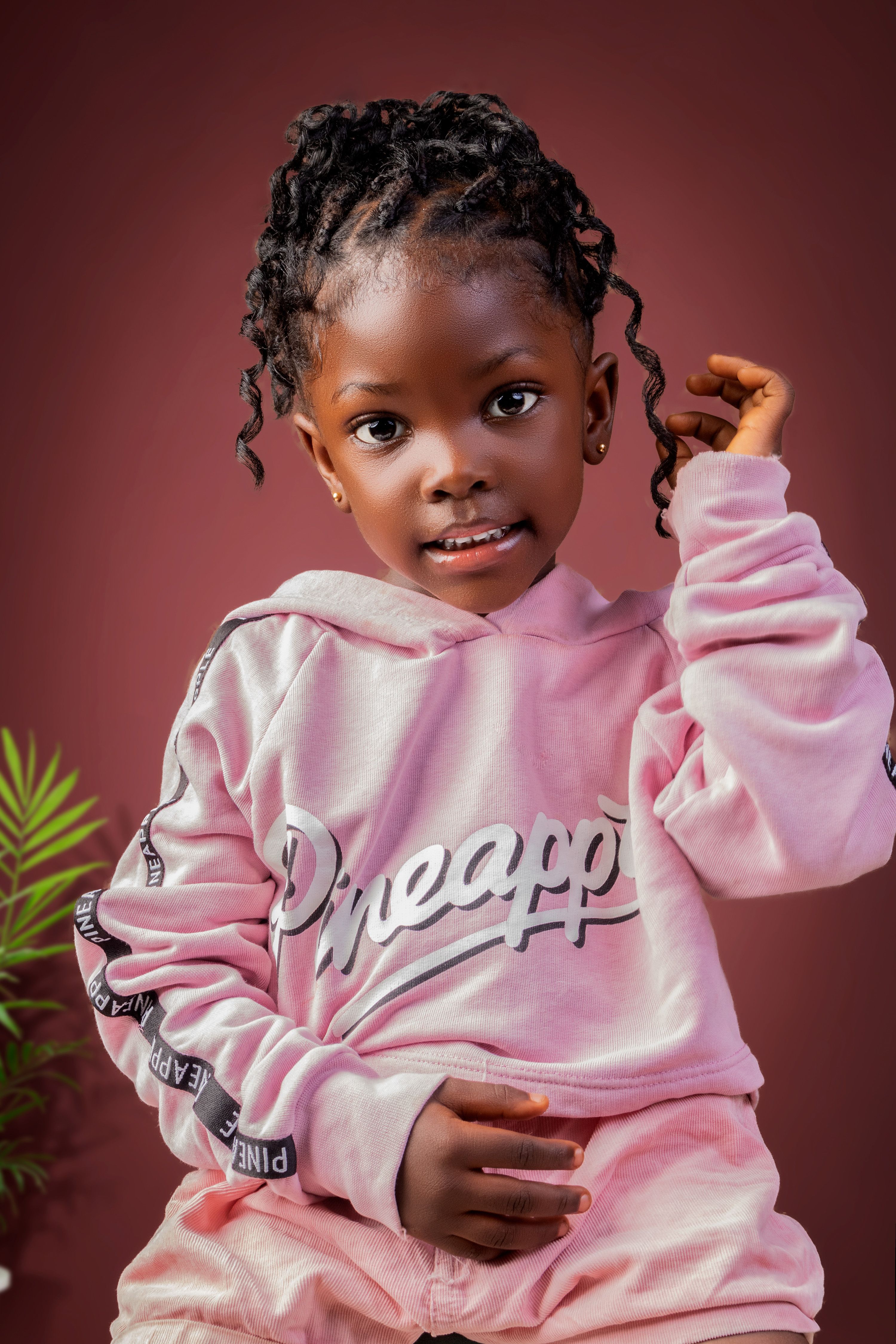 Charming portrait of a young child wearing a pink hoodie indoors.