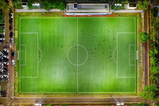 Stunning aerial view of a soccer field in Jakarta, Indonesia at night with players in action.