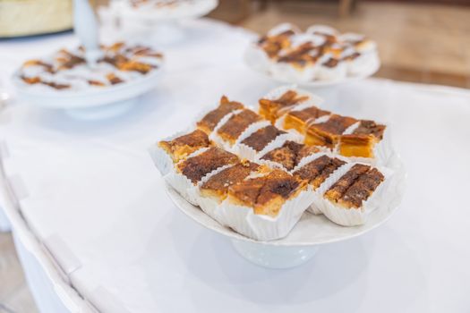 Assorted pastries with flaky crusts and golden tops arranged on white platters.
