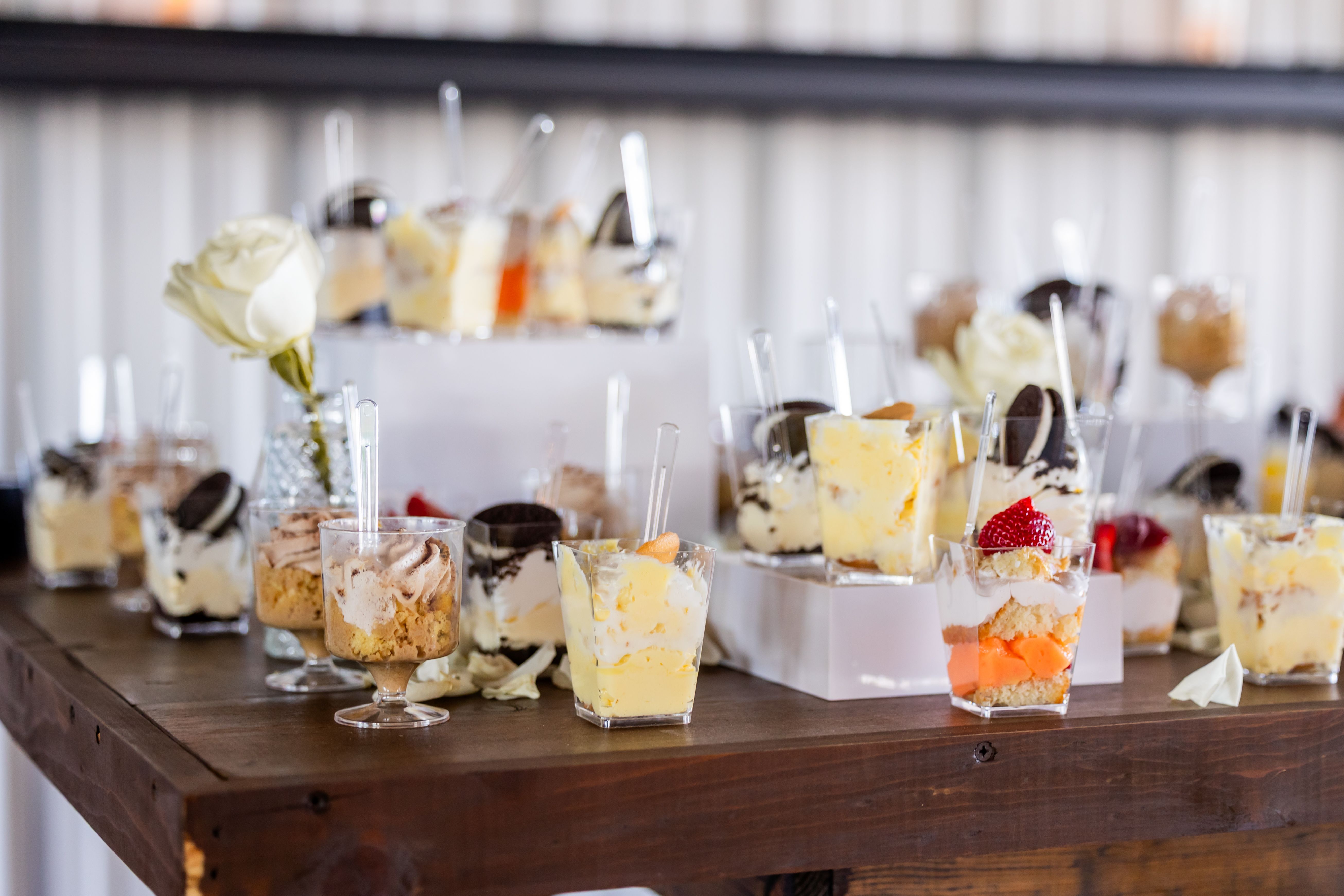 An elegant dessert buffet featuring assorted mini parfaits in stylish glass cups, perfect for events.