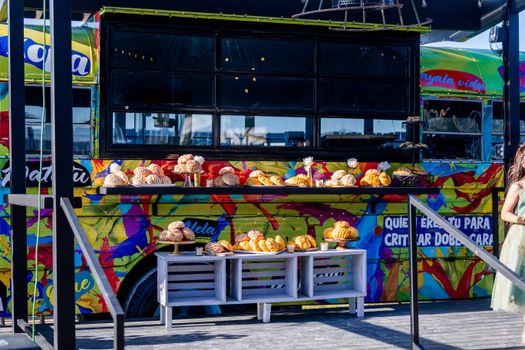 Colorful food truck displaying a variety of Mexican pastries outdoors. Perfect for marketing vibrant street food culture.