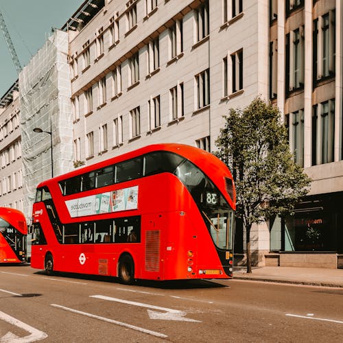 도시의 거리를 지나가는 빨간 이층 버스