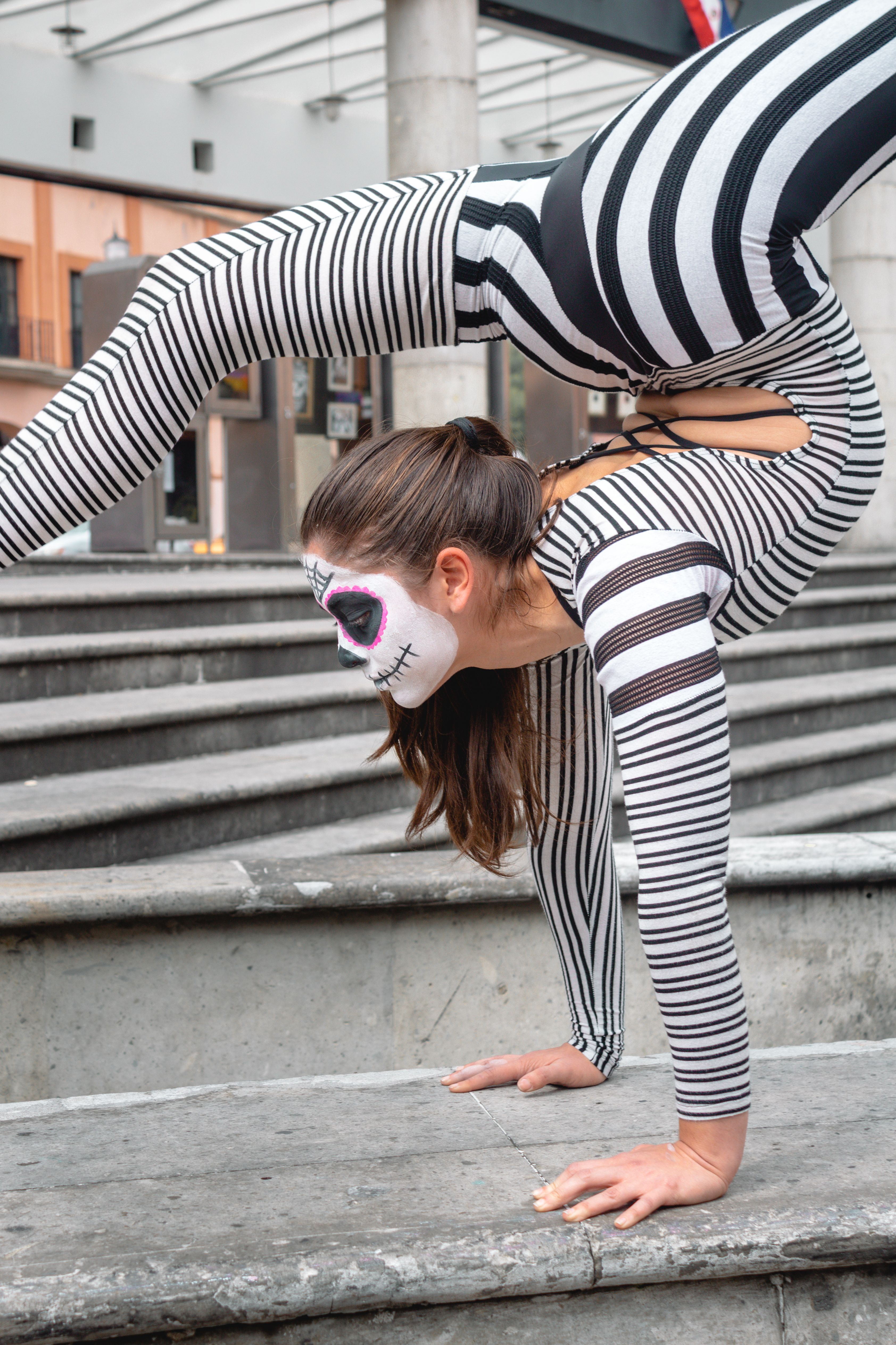 Female Acrobat Performing in Striped Bodysuit · Free Stock Photo
