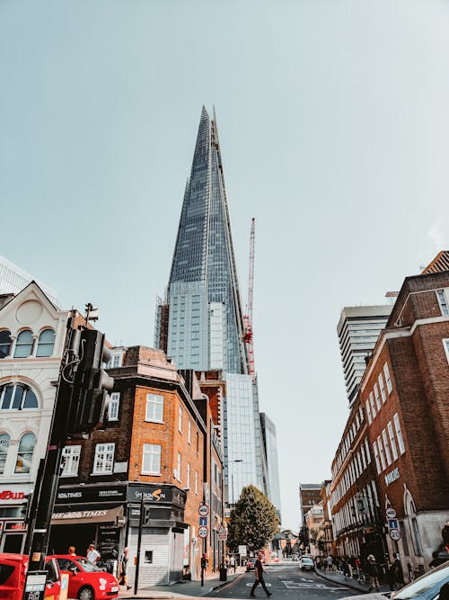 Free People Walking on Pathway Near Buildings and Different Vehicles on Road Stock Photo