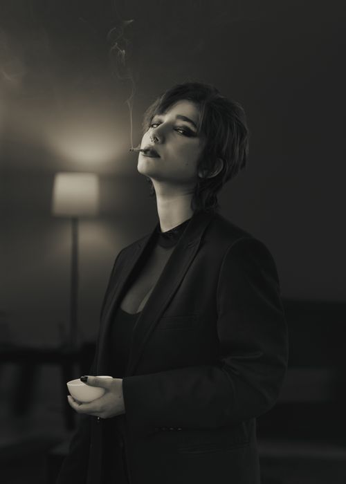Free A contemplative individual smoking indoors, evoking a vintage and dramatic mood. Stock Photo