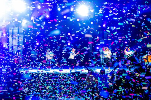 Energetic concert scene with confetti rain and colorful stage lights. Perfect for event promotion.