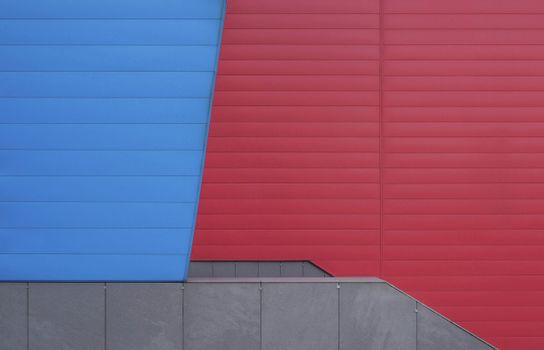 Modern architectural facade with striking red and blue panels in geometric design.