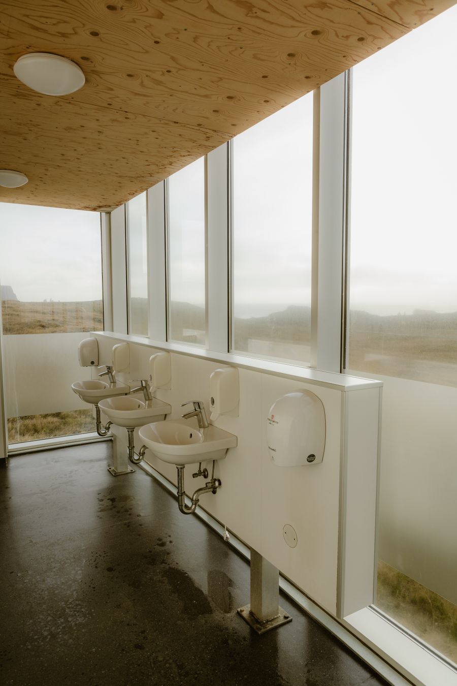 Clean campground washroom with sinks and a wall of windows