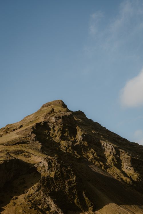 Free A serene view of a mountain peak with rugged terrain under a clear blue sky, perfect for nature enthusiasts. Stock Photo