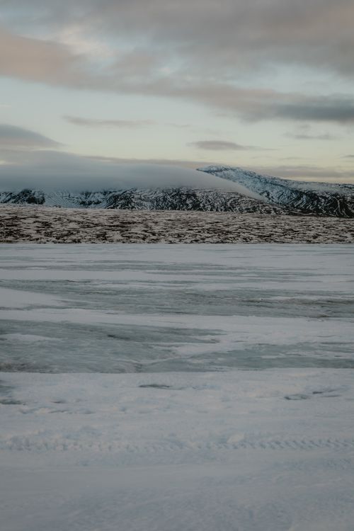 Free Breathtaking winter scene with snowy mountain range under a cloudy sky. Stock Photo