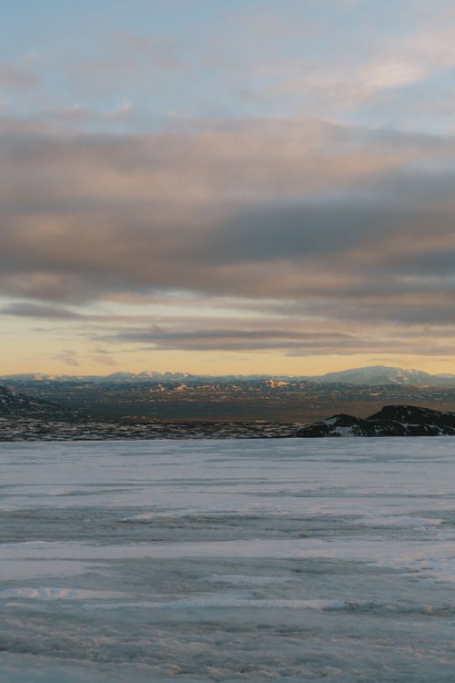 Free Vast snowy landscape under a dramatic sky, showcasing serene winter beauty. Stock Photo