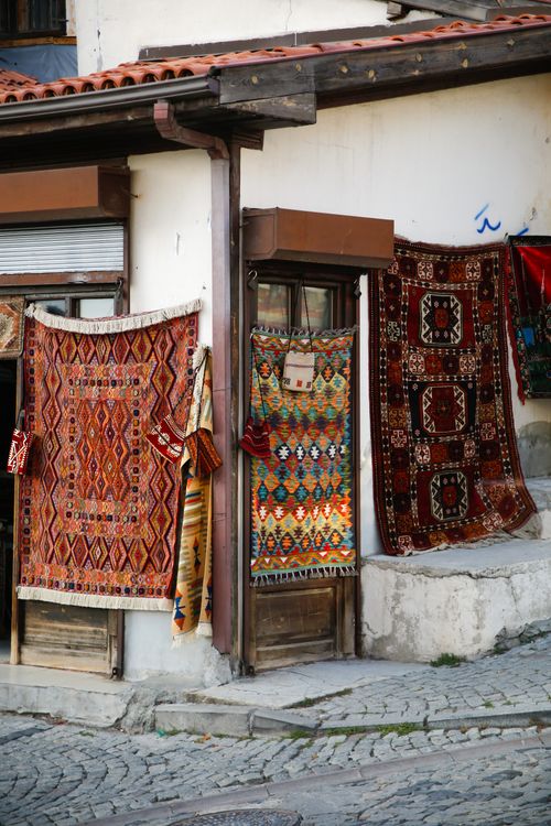 Free Colorful Turkish rugs hanging outside a shop in a street market, showcasing intricate patterns. Stock Photo