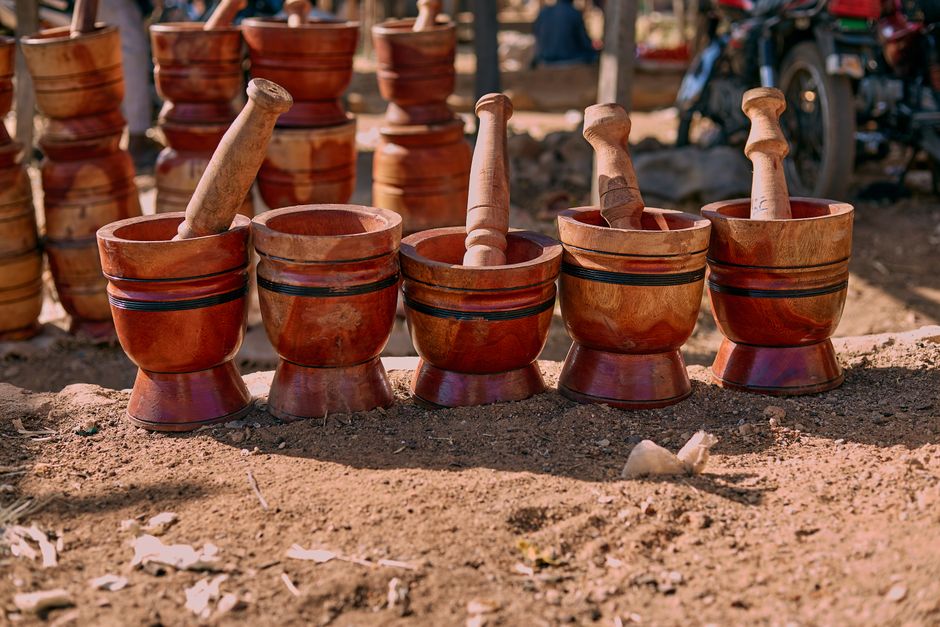 Cinco pilões de madeira artesanais representando as 5 Forças de Porter em um cenário natural, simbolizando a análise da competitividade setorial e investimentos.