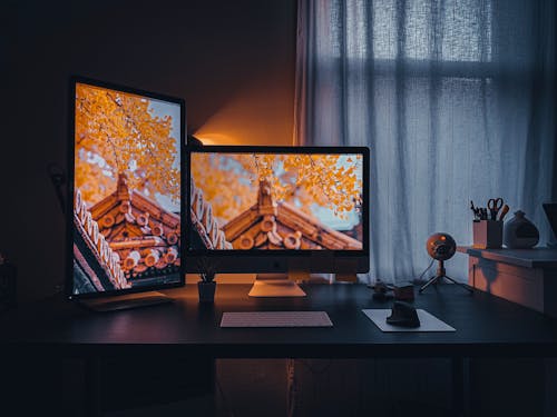 Free Two Turned-on Flat Screen Computer Monitors on Desk Stock Photo