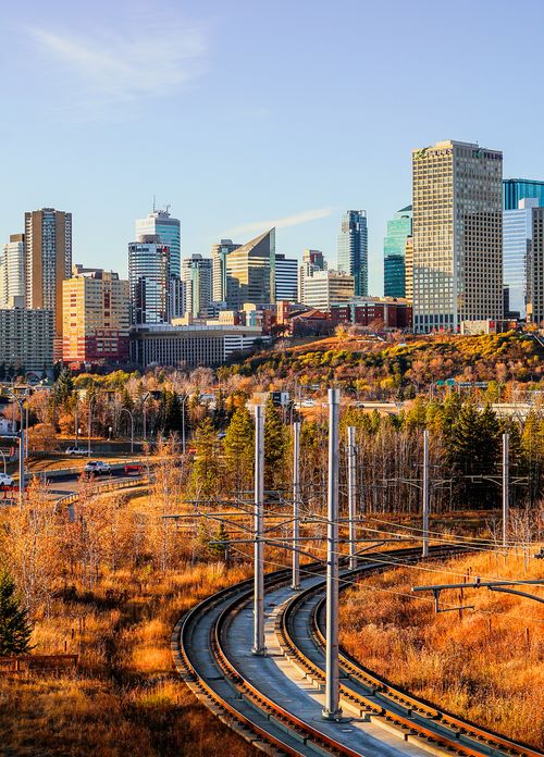 Free Vibrant autumn cityscape featuring skyline and train tracks at dawn. Stock Photo
