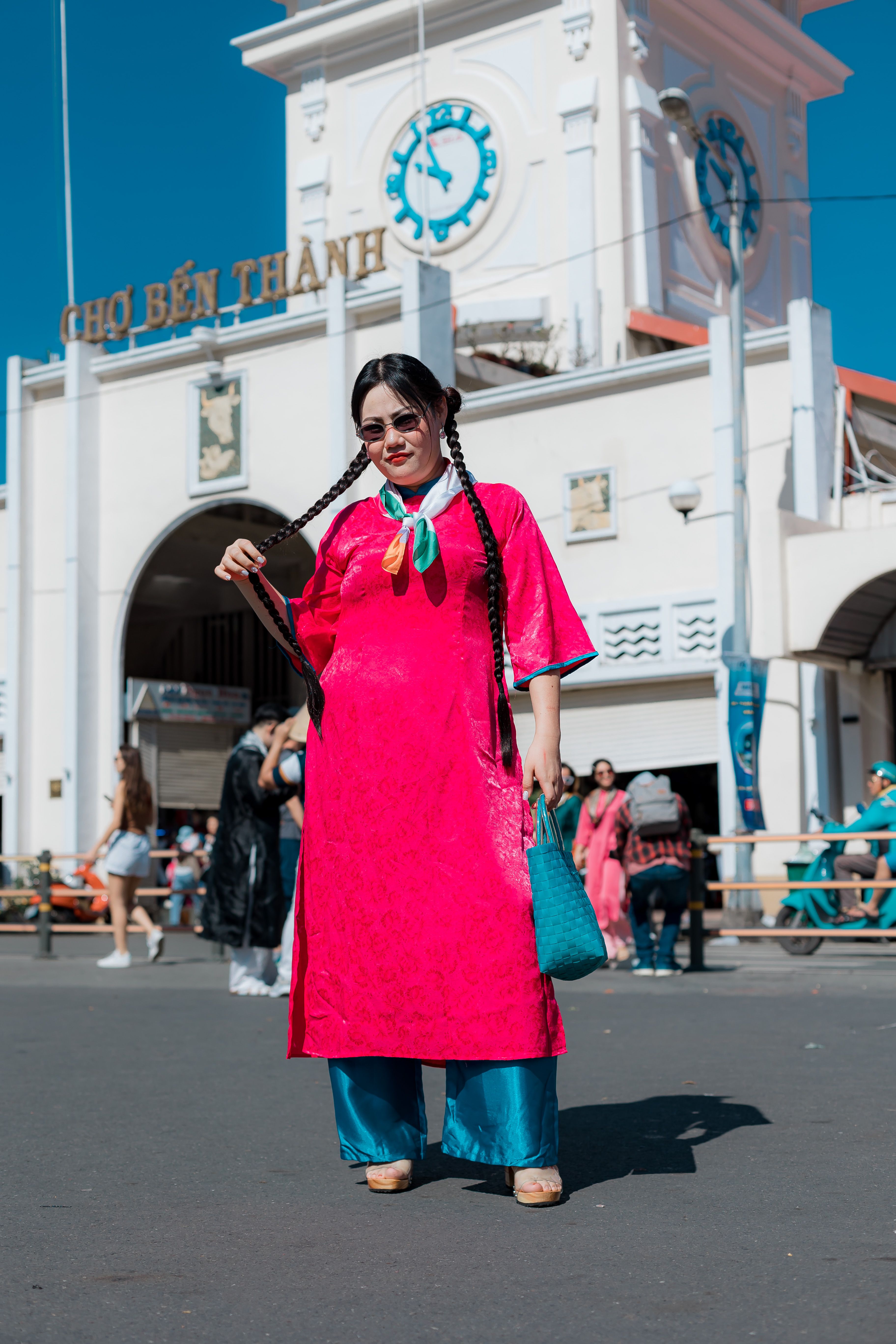 [ColoSach]-woman-in-vibrant-ao-dai-poses-confidently-at-the-iconic-ben-thanh-market.