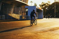 在充满活力的城市环境中，骑自行车的人享受着日落骑行，捕捉休闲与旅行的精髓