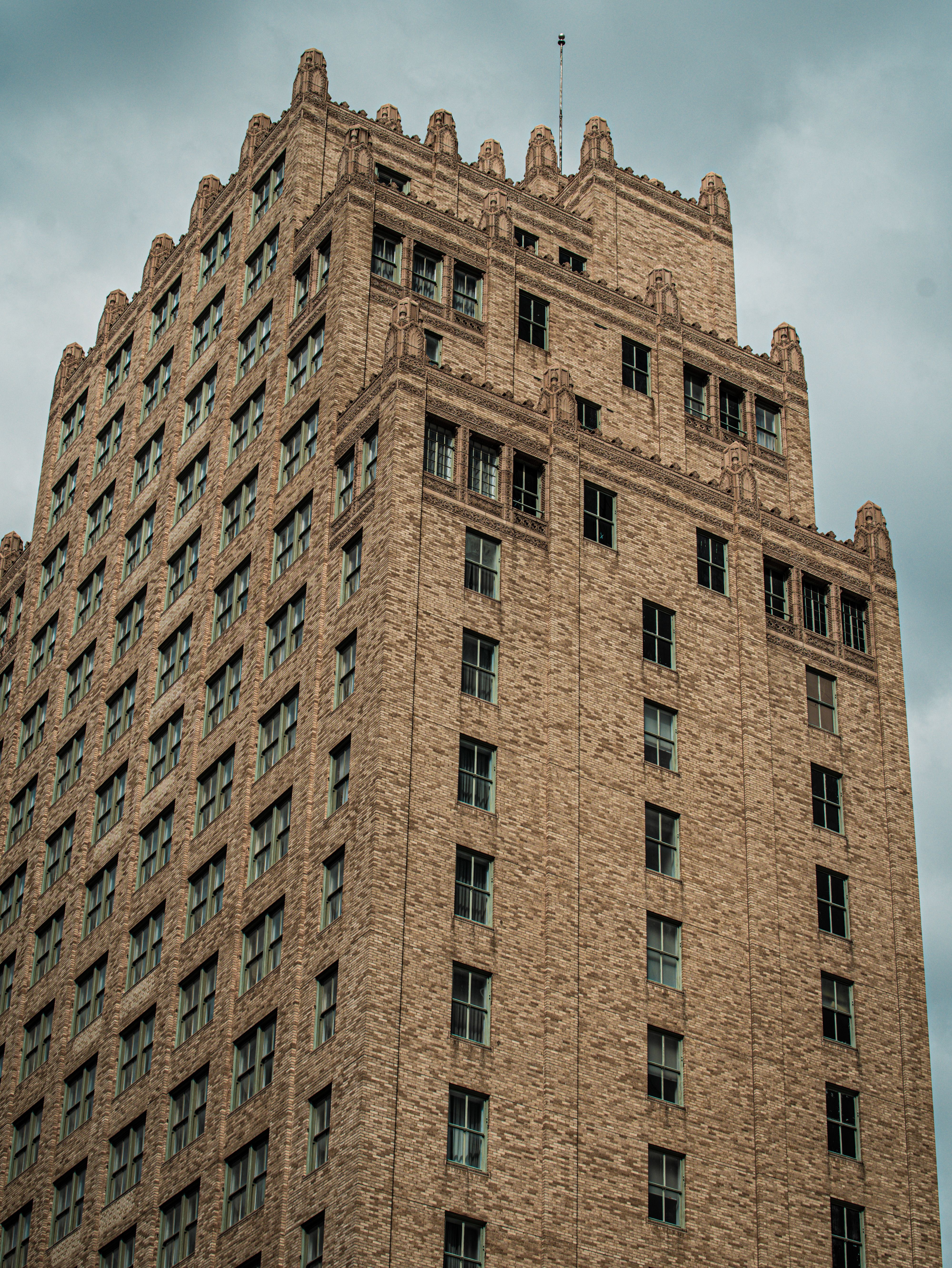Historic Brick Building Against Cloudy Sky · Free Stock Photo