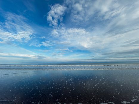 Serene beach view in Ecuador with reflections and dramatic sky, perfect for tranquil and nature themes.