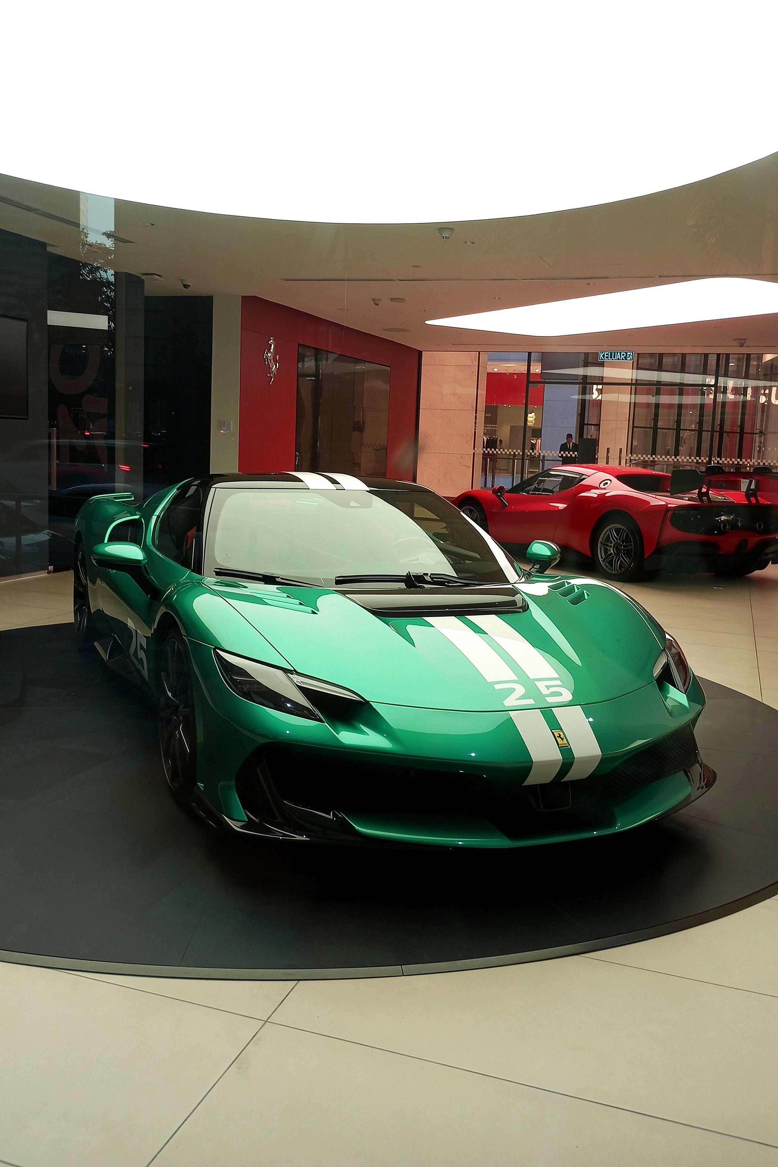 Free Captivating green Ferrari on display in a luxurious showroom. Stock Photo