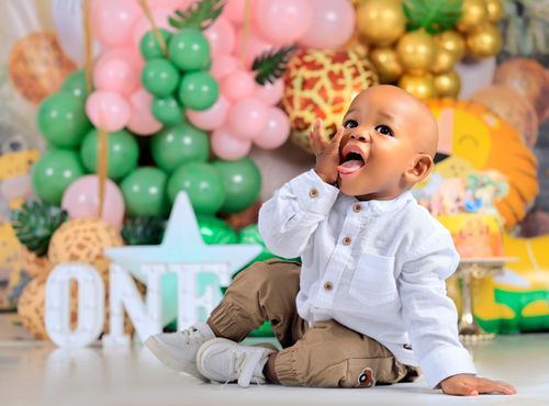 Free Adorable baby celebrating first birthday with colorful balloons and decorations indoors. Stock Photo