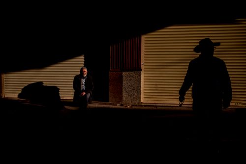 Free Moody urban scene capturing silhouetted figures and shadows in low light. Stock Photo