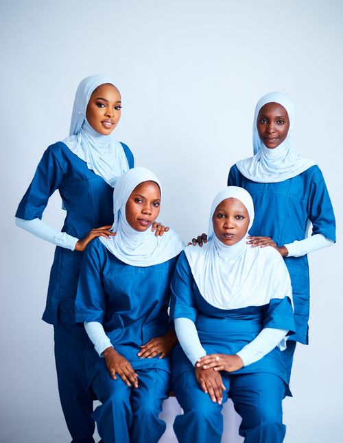 Free Four African nurses wearing hijabs and blue uniforms posing indoors. Stock Photo