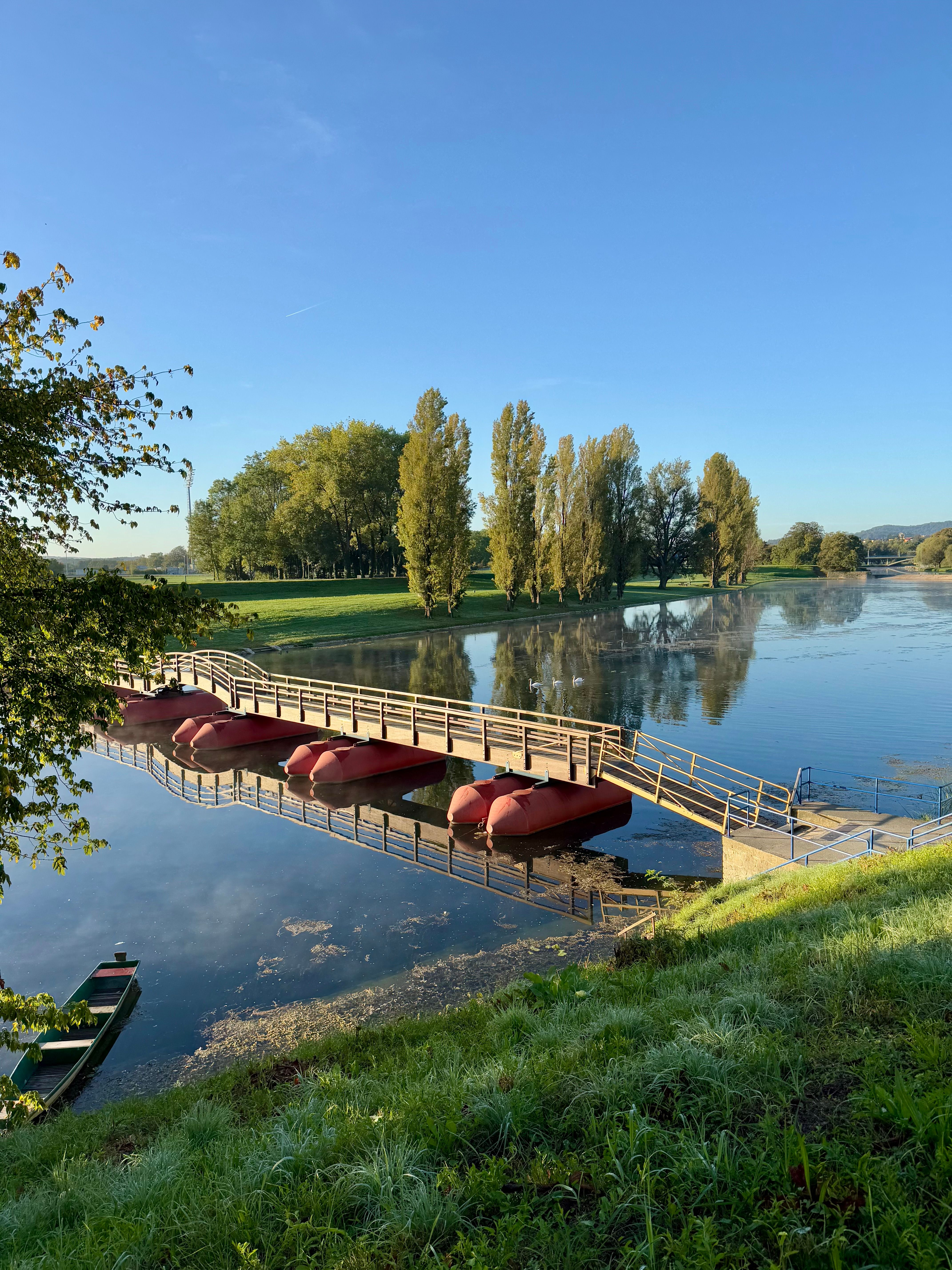 Gratis Fredfyldt udsigt over en fredfyldt flod med en bro og både i Karlovac, Kroatien. Lagerfoto