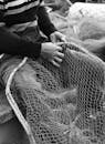 Black and White Fisherman Mending Net