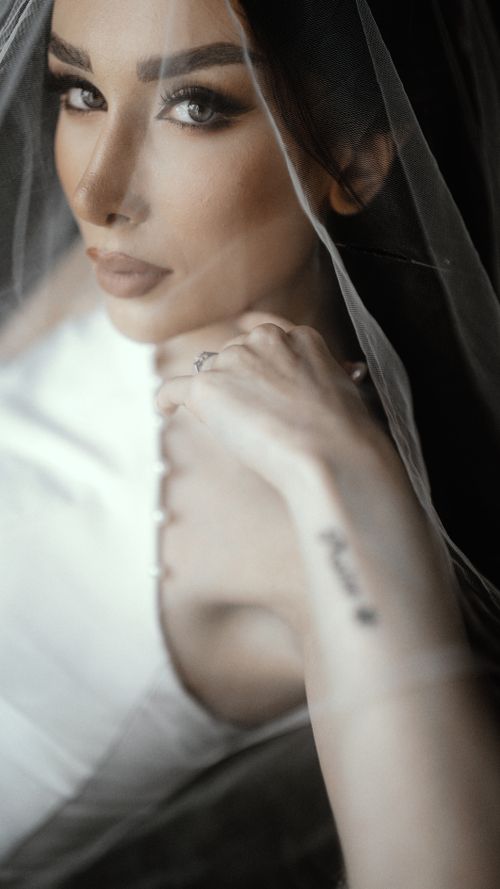 Free Stunning portrait of a beautiful bride in elegant attire under a delicate veil. Stock Photo